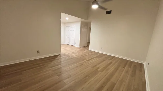 a view of an empty room with wooden floor