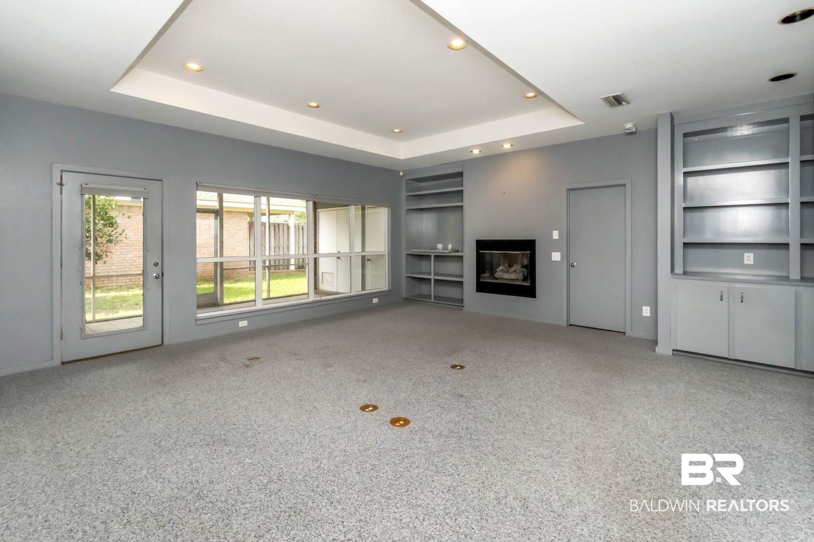1205 Hillcrest Crossing East Mobile, AL 36695 - Photo 11 of 40 Unfurnished living room featuring a raised ceiling, built in features, and carpet floors