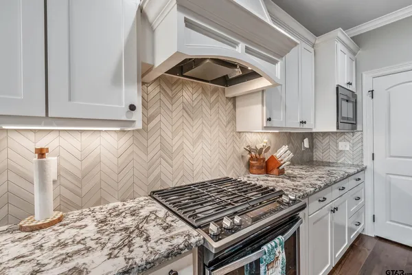 a kitchen with stainless steel appliances a sink a stove and a microwave