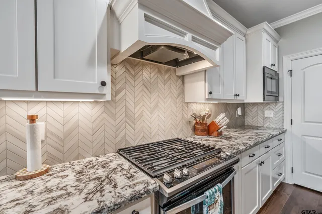 a kitchen with stainless steel appliances a sink a stove and a microwave