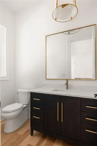 a bathroom with a granite countertop sink mirror vanity and toilet