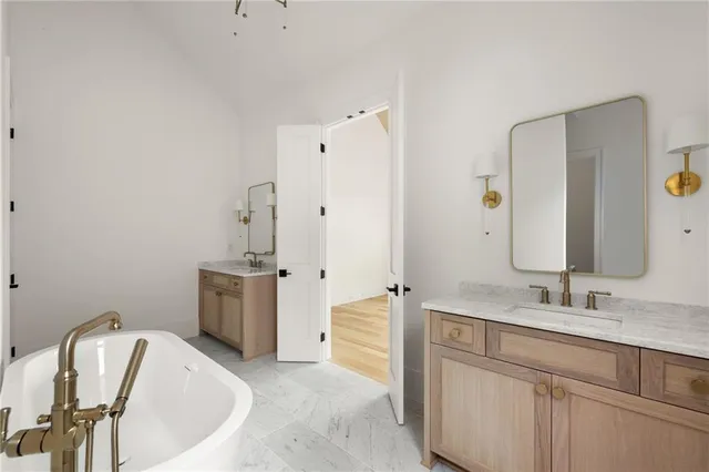 a spacious bathroom with a tub sink and mirror
