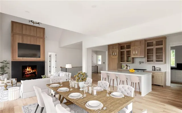 a open dining room with furniture a fireplace and wooden floor