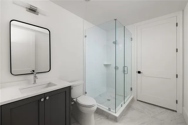 a bathroom with a double vanity sink toilet and shower