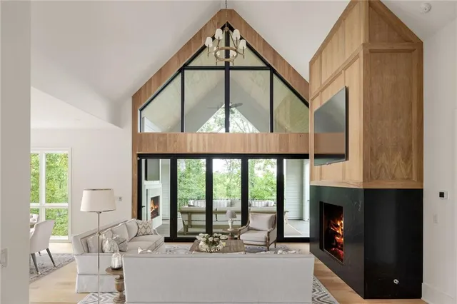 a living room with large windows and a chandelier