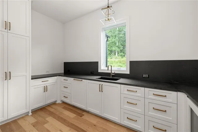 a kitchen with granite countertop white cabinets and black appliances