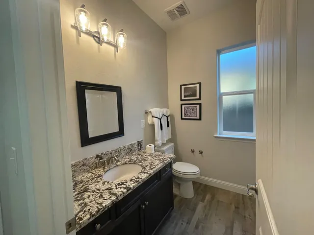 a bathroom with a granite countertop sink and a mirror