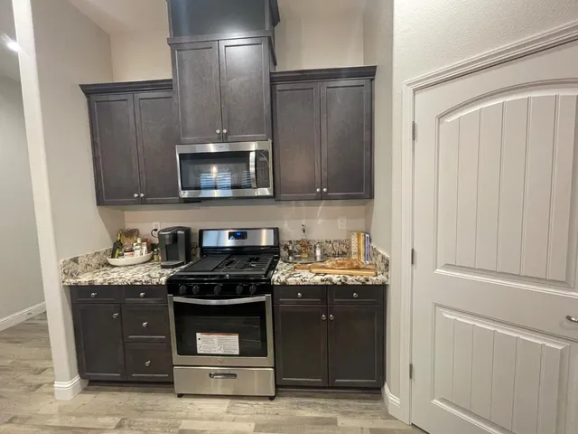 a kitchen with granite countertop a stove and a microwave