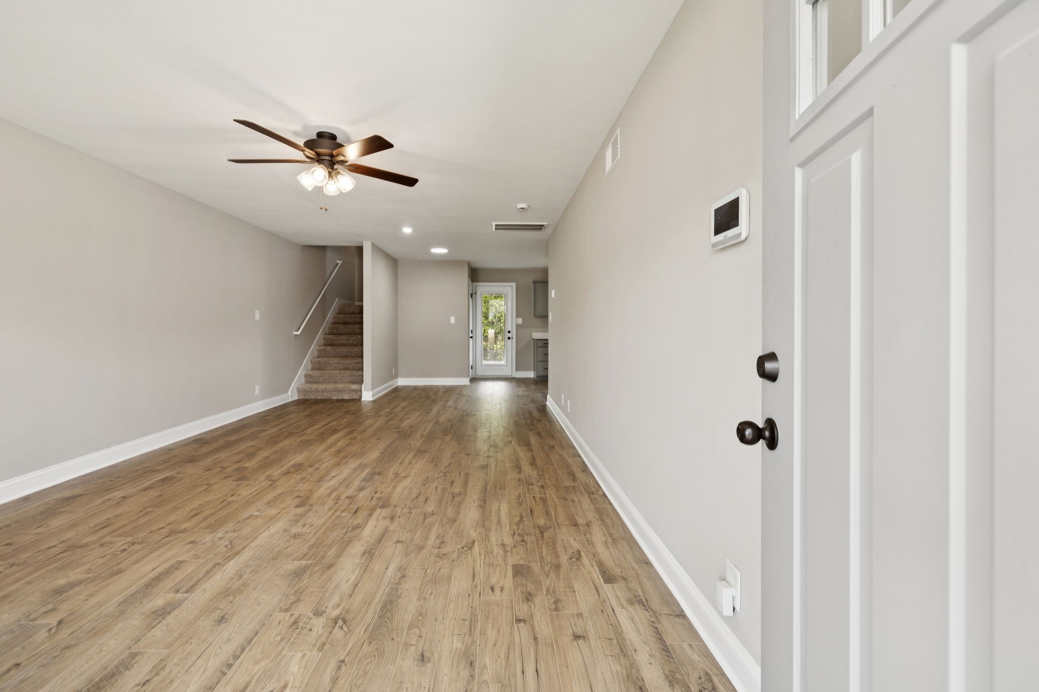 1304 Racker Drive Clarksville, TN 37043 - Photo 4 of 35 a view of a hallway with wooden floor and a ceiling fan