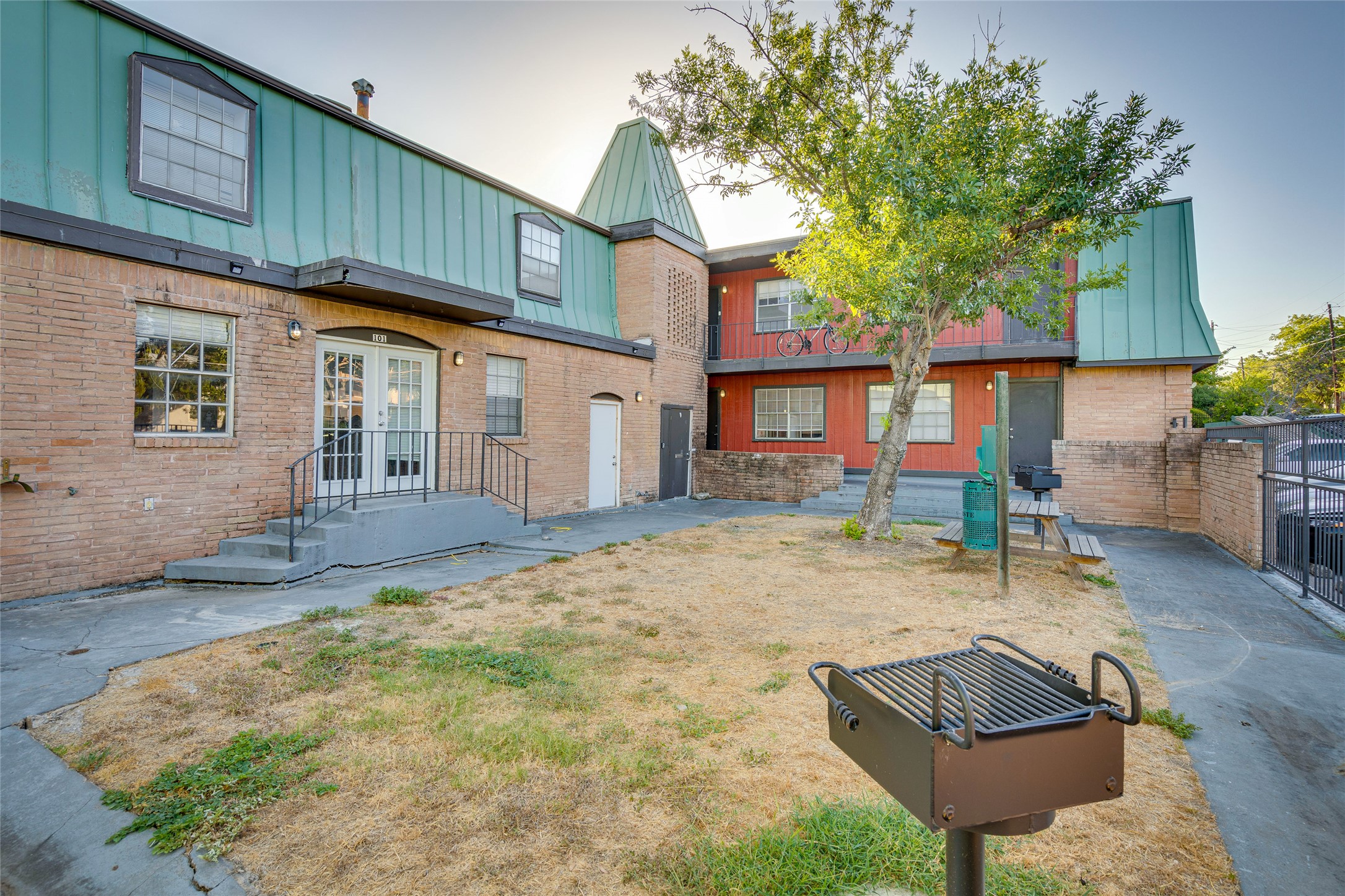 307 East 31st Street, Unit 106 Austin, TX 78705 - Photo 10 of 12 a backyard of a house with barbeque oven table and chairs
