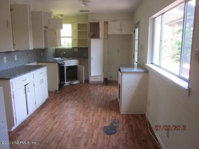 2452 Bayview Road Jacksonville, FL 32210 - Photo 6 of 14 a kitchen with wooden floors and white cabinets