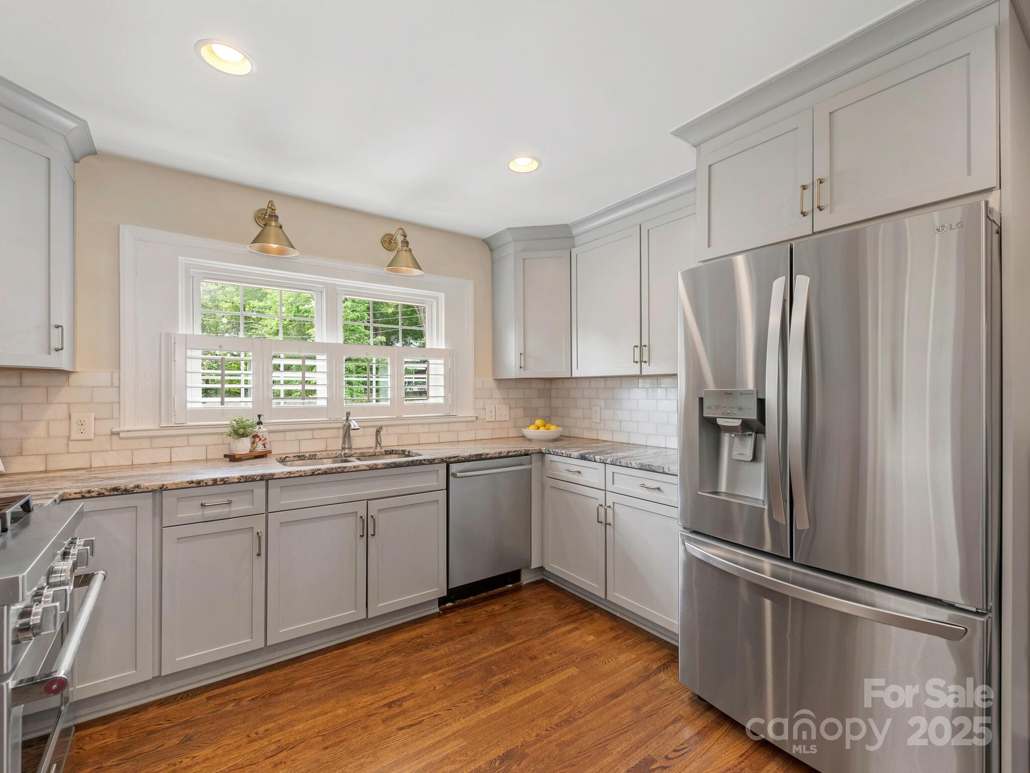 4346 Walker Road Charlotte, NC 28211 - Photo 11 of 30 a kitchen with stainless steel appliances granite countertop a refrigerator sink and wooden floor