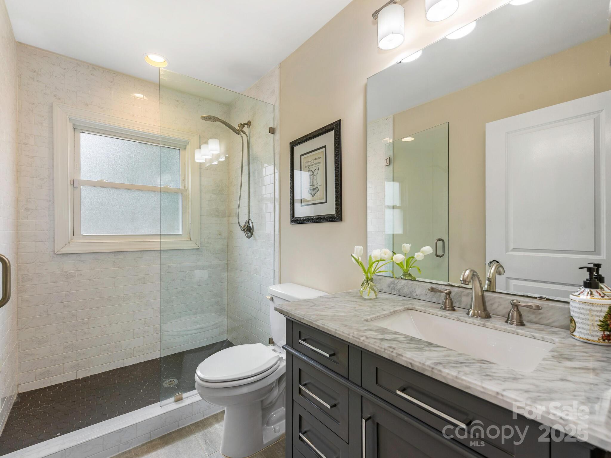 4346 Walker Road Charlotte, NC 28211 - Photo 18 of 30 a bathroom with a granite countertop toilet sink and mirror