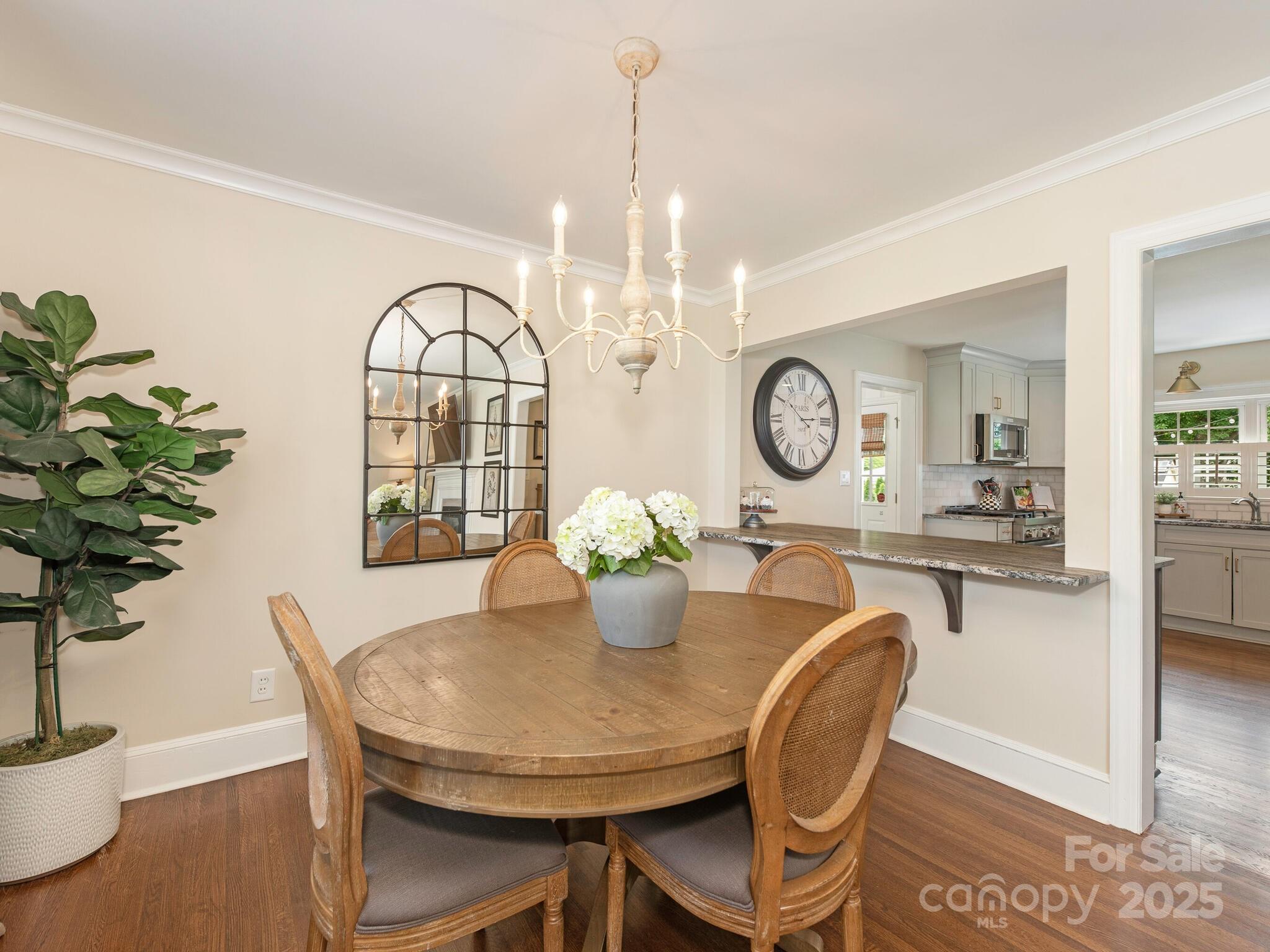 4346 Walker Road Charlotte, NC 28211 - Photo 9 of 30 a dining room with furniture a potted plant and a chandelier