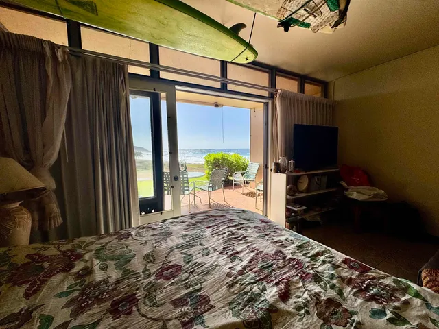 a bedroom with a bed and a flat tv screen on dresser