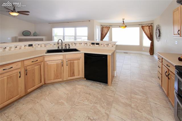 12010 Rio Secco Road Peyton, CO 80831 - Photo 6 of 36 Spacious eat-in kitchen with new 12" x 24" porcelain tile and raised island with breakfast bar.