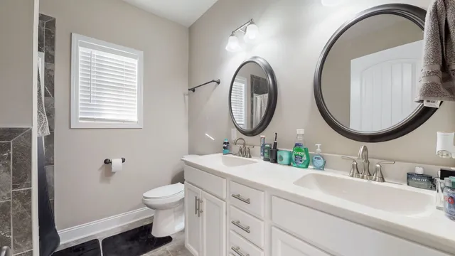 a bathroom with a granite countertop toilet a sink and a mirror
