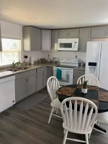 a kitchen with granite countertop white cabinets and stainless steel appliances