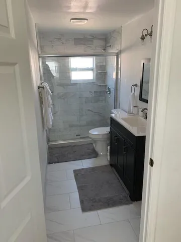 a bathroom with a sink a toilet and shower