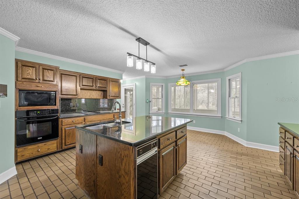 2545 Crooked Creek Point Road Middleburg, FL 32068 - Photo 21 of 54 a kitchen with granite countertop a stove and a sink