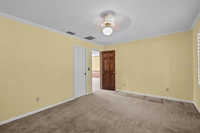 a view of an empty room with a ceiling fan