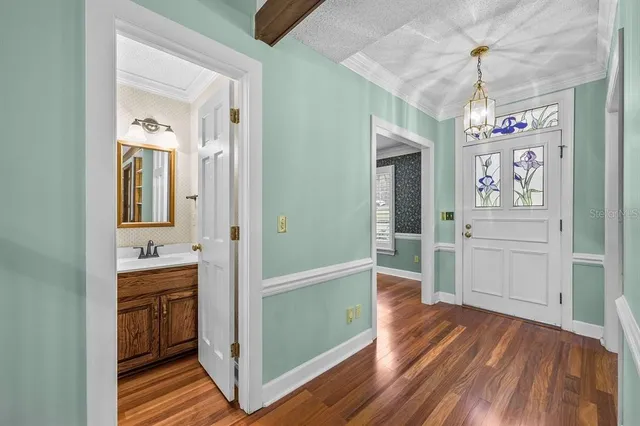 a view of a room with wooden floor fan and windows