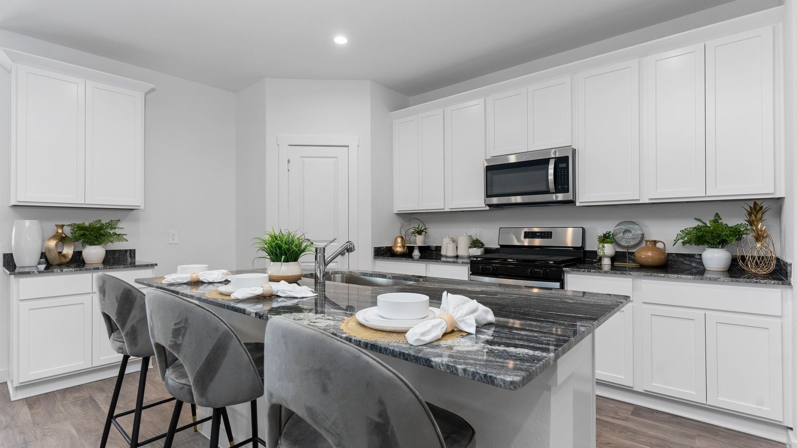 6107 Brookhaven Street Rosenberg, TX 77469 - Photo 14 of 40 a kitchen with granite countertop stainless steel appliances a stove a sink a microwave a dining table and chairs