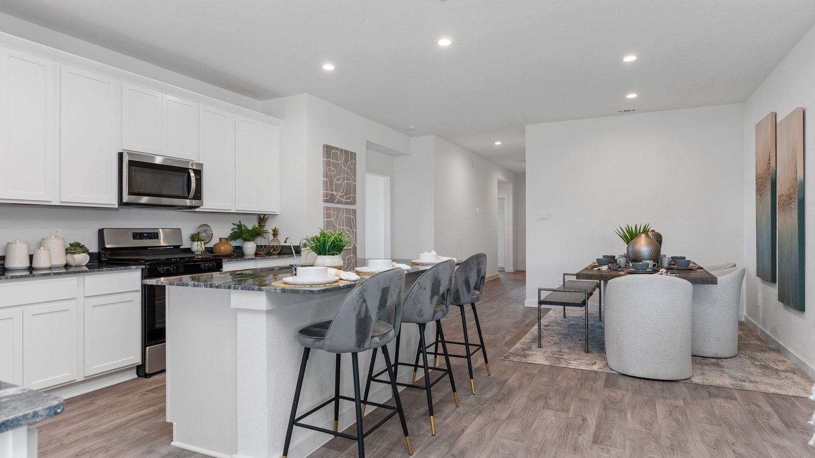 6107 Brookhaven Street Rosenberg, TX 77469 - Photo 15 of 40 a kitchen with stainless steel appliances granite countertop a stove a sink a refrigerator a microwave a dining table and chairs with wooden floor