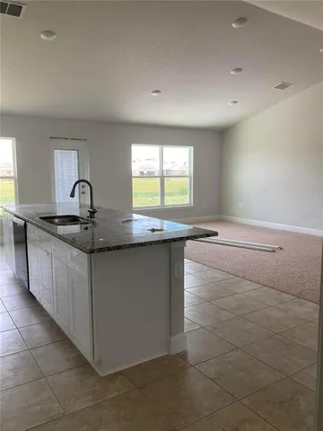 a kitchen with granite countertop a sink and a stove top oven