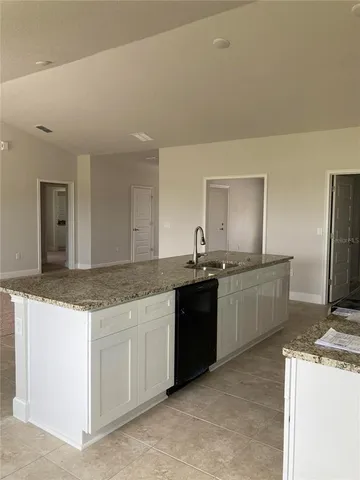 a kitchen with granite countertop a sink and cabinets