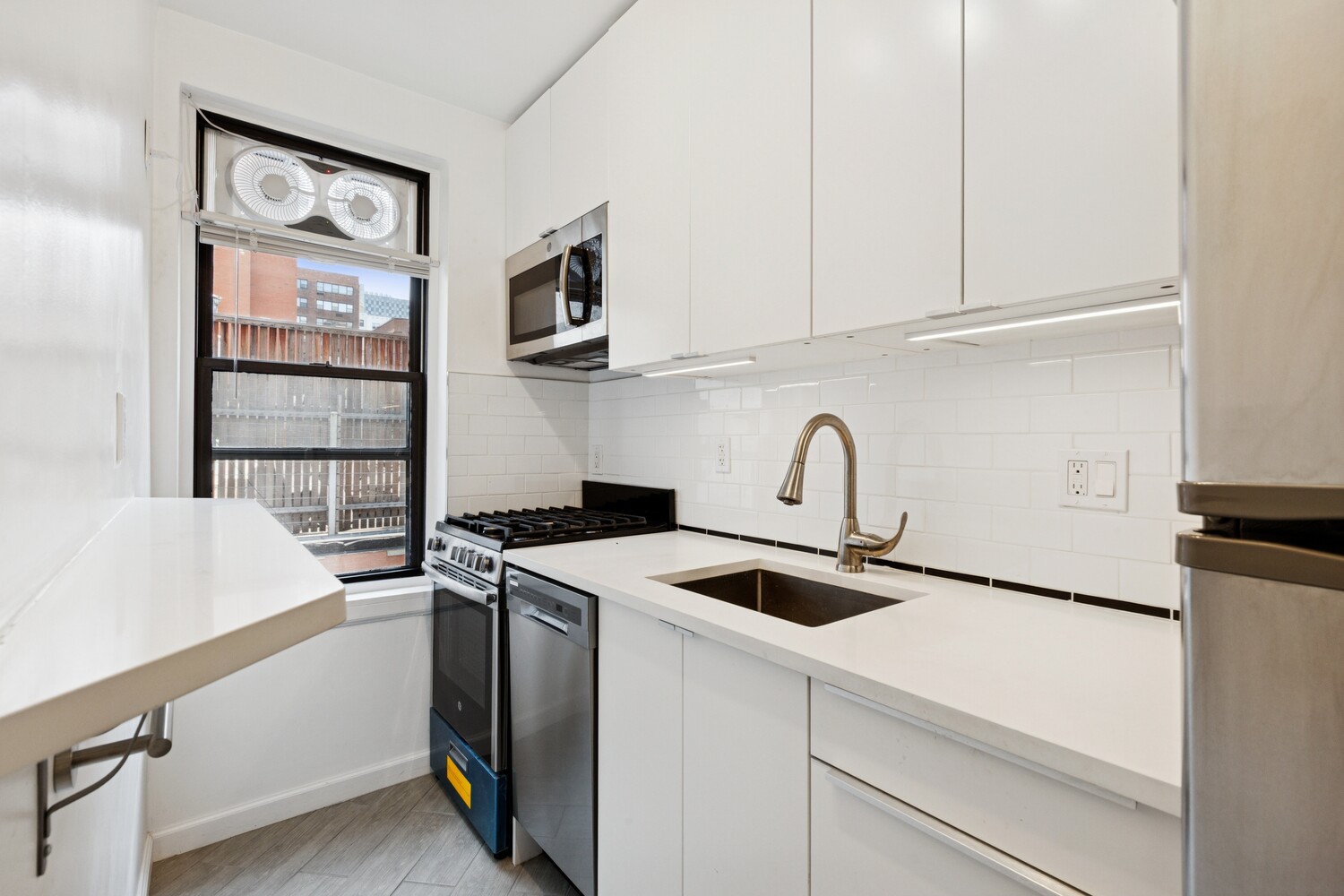 208 East 70th Street, Unit 6F Manhattan, NY 10021 - Photo 11 of 13 a view of kitchen with stainless steel appliances granite countertop a sink and a microwave