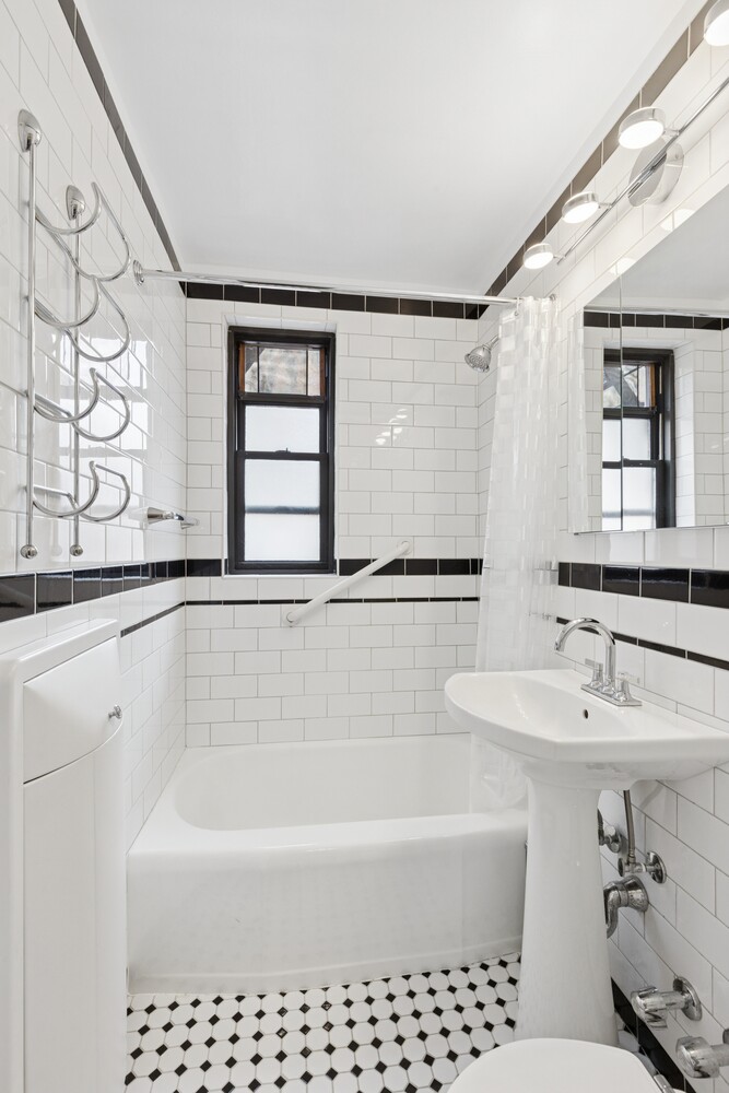 208 East 70th Street, Unit 6F Manhattan, NY 10021 - Photo 12 of 13 a bathroom with a bathtub a sink a window and a shower