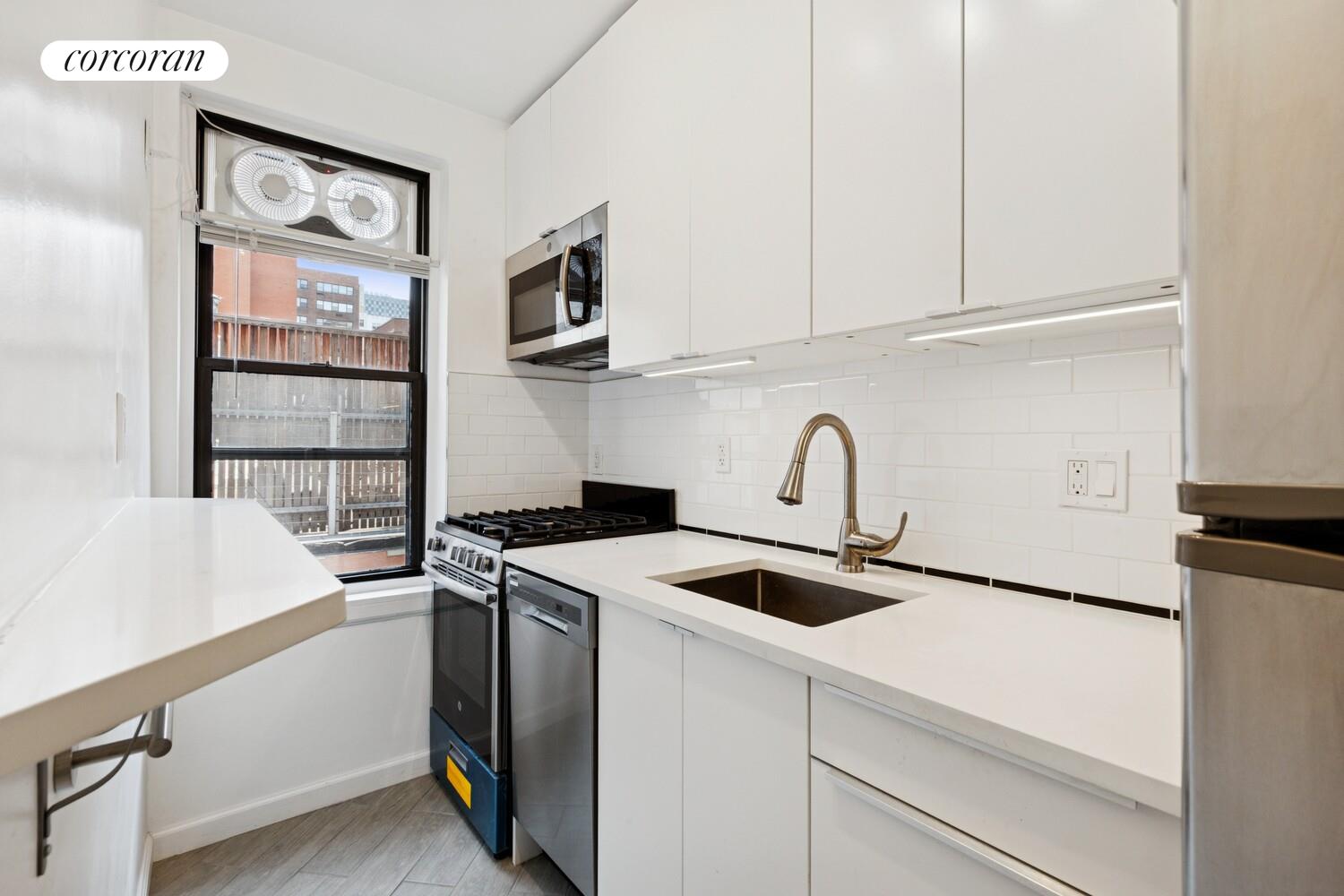 208 East 70th Street, Unit 6F Manhattan, NY 10021 - Photo 5 of 13 a view of kitchen with stainless steel appliances granite countertop a sink and a microwave