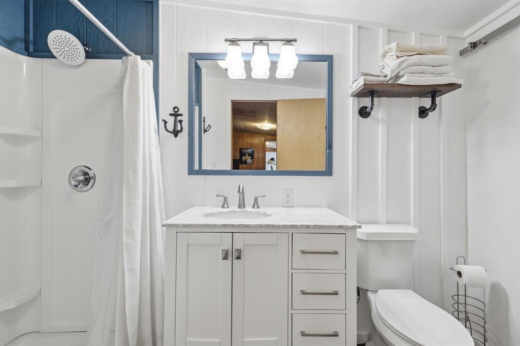 4513 Chapel Road Graham, TX 76450 - Photo 16 of 38 a bathroom with a sink vanity mirror and toilet