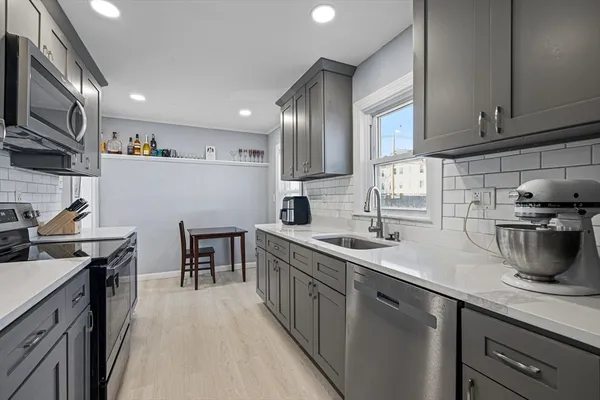 a kitchen with stainless steel appliances granite countertop a sink a stove and cabinets