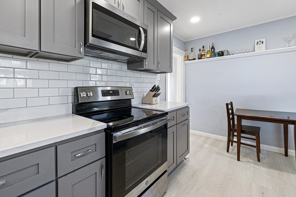 57-59 Larchwood Road, Unit 1 Methuen, MA 01844 - Photo 6 of 16 a kitchen with stainless steel appliances a stove microwave and cabinets