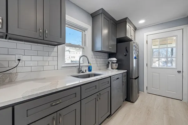 a kitchen with stainless steel appliances granite countertop a sink a refrigerator and cabinets