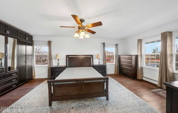 a large bedroom with a bed and wooden floor