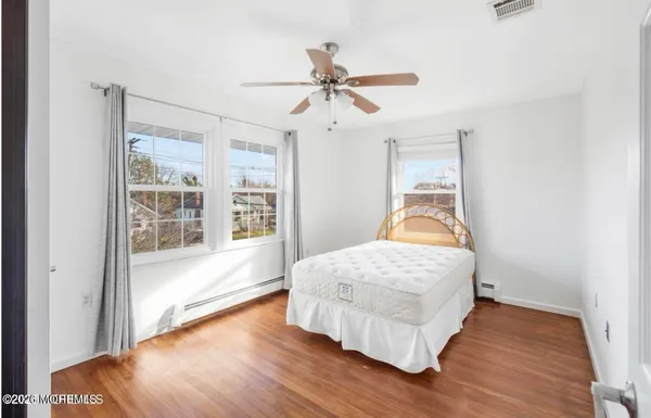a bedroom with a bed and wooden floor