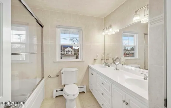 a bathroom with a double vanity sink toilet and shower