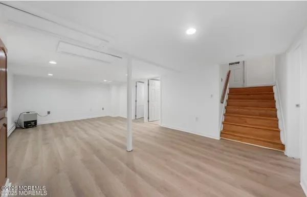 an empty room with wooden floor and white walls