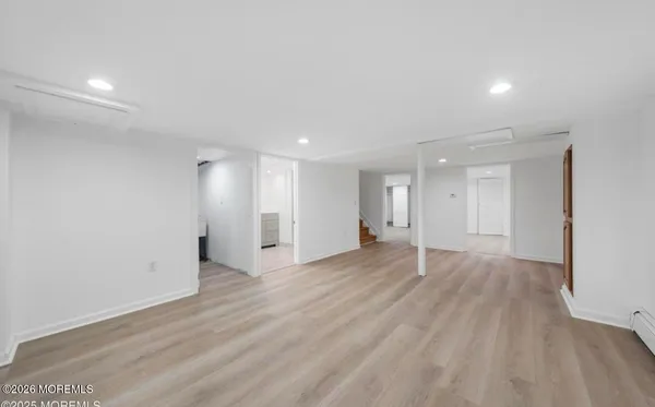 an empty room with wooden floor & windows