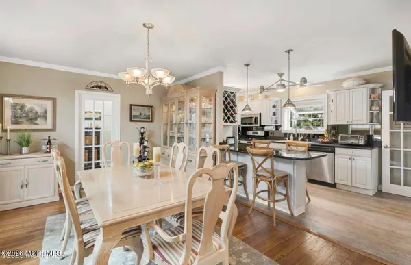 a room with stainless steel appliances kitchen island granite countertop furniture and a chandelier