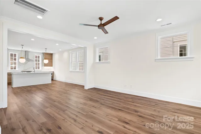 an open kitchen with wooden floor and stainless steel appliances
