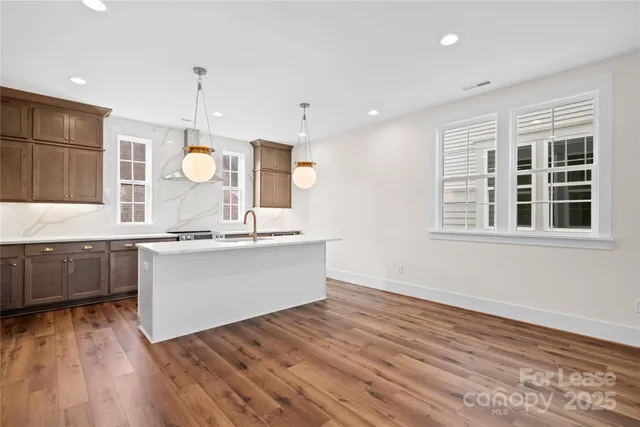 a view of kitchen with granite countertop stainless steel appliances and sink