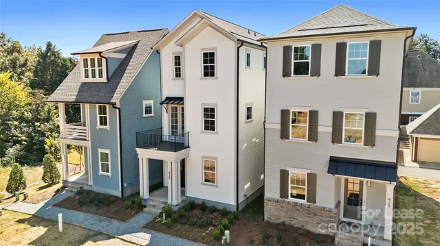 a view of a white house with a yard and plants