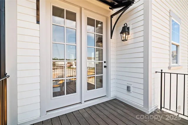 an empty room with wooden floor chandelier and windows