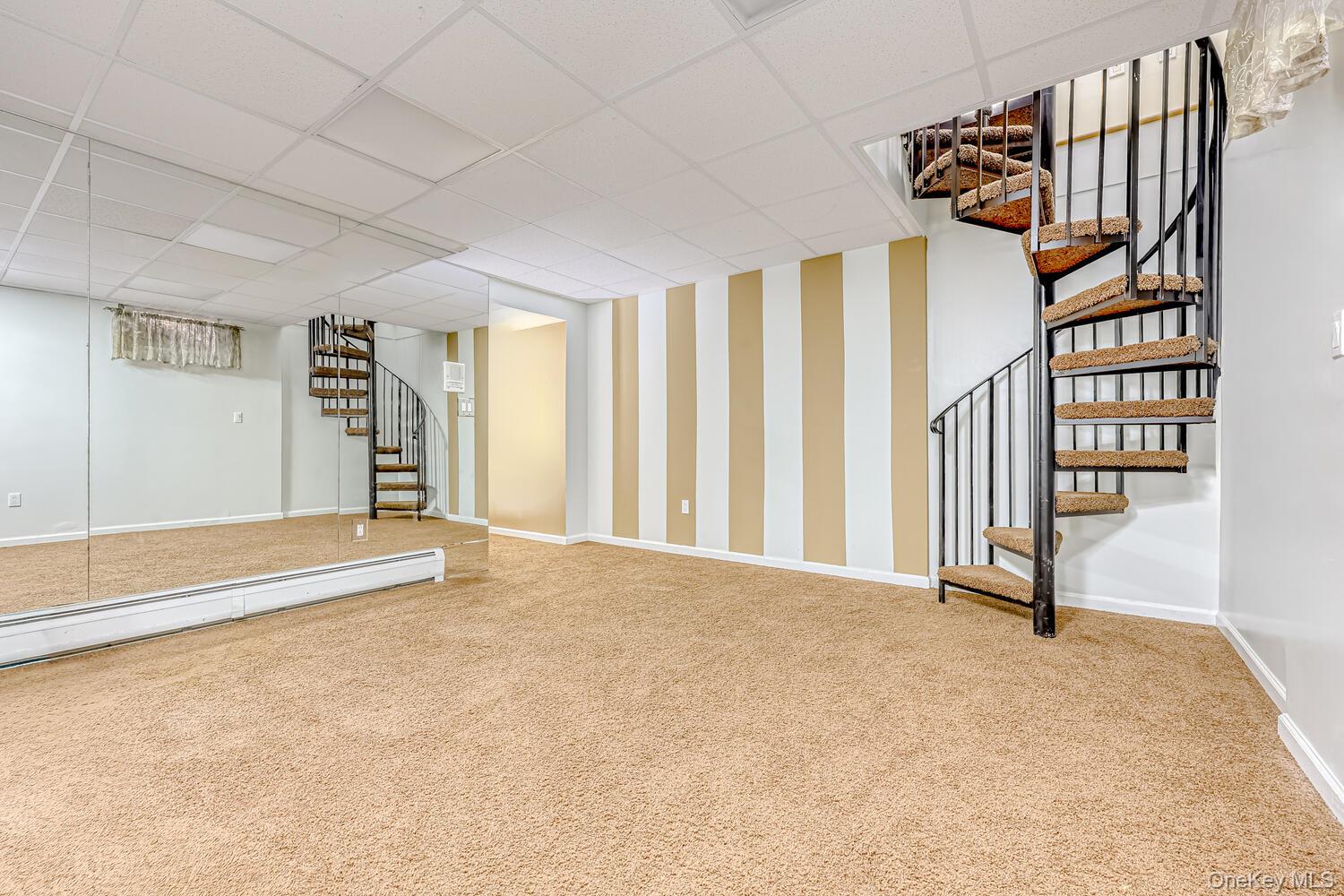22 Golden Road Suffern, NY 10901 - Photo 35 of 41 Finished basement with stairway, carpet flooring, a paneled ceiling, and wallpapered walls