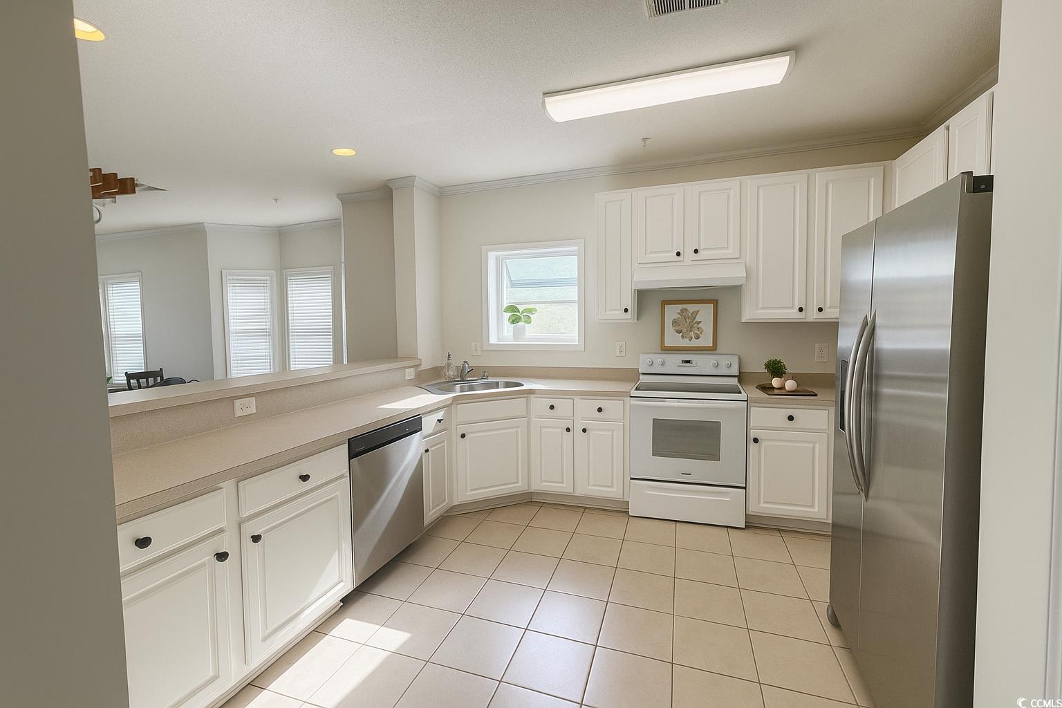 1100 Commons Boulevard, Unit 508 Myrtle Beach, SC 29572 - Photo 7 of 24 Kitchen with stainless steel appliances, white cabinetry, light tile patterned floors, crown molding, and recessed lighting