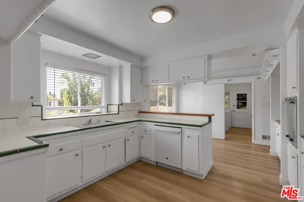 a kitchen with granite countertop a sink cabinets window and stainless steel appliances